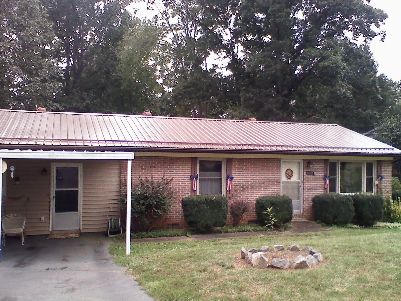 Bronze metal roof and carport on a brick ranch home — Roof Repair work by our crew in Loughman